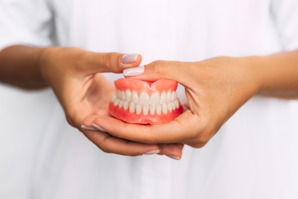 Dentist holding a denture set