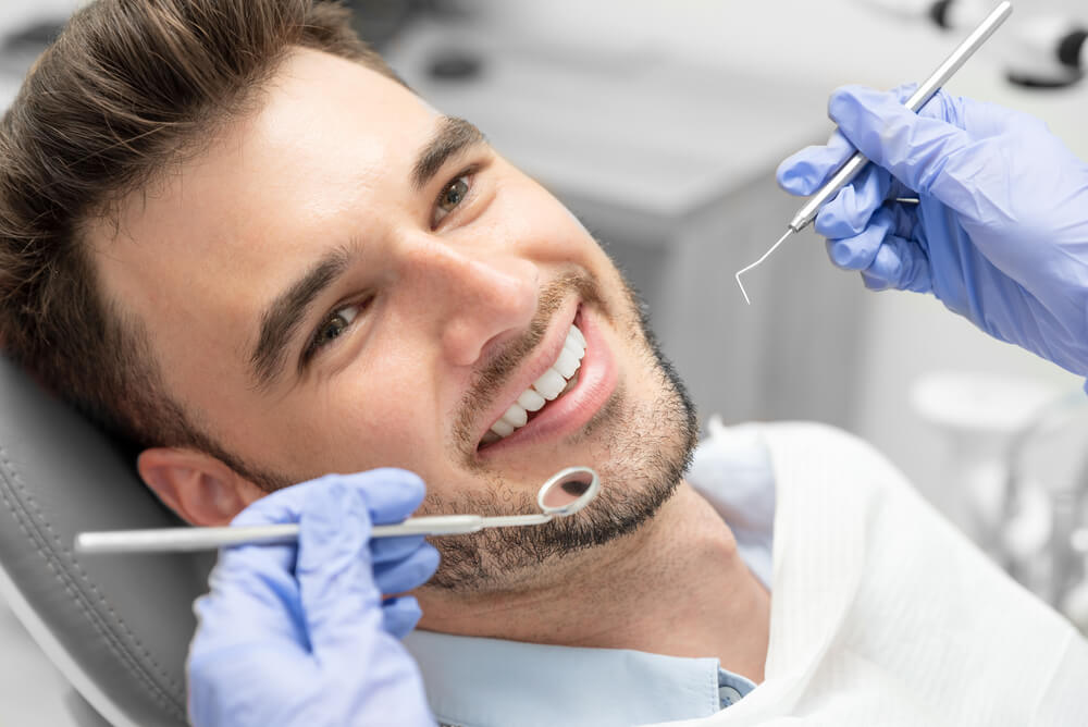 Man smiling while getting his dental exam